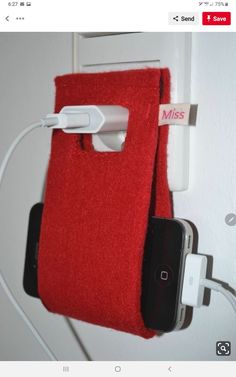 a red towel hanging from the side of a wall next to an iphone charger