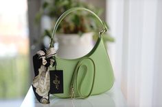 Elegant and trendy women's leather handbag in mint green. The handbag impresses with its asymmetrical, stylish shape and the attached stylish cloth. The highlight: the handbag can be worn as a forearm or wrist bag or - thanks to the additional attachable strap (gold-colored carabiners) - as a shoulder crossbody bag. The bag closes at the top with a gold-colored zipper. Inside the bag there is a small compartment with a zipper. Dimensions Width about 28 cm Height approx. 18 cm / 27 cm Width: appr Wrist Bag, Leather Zipper, Leather Handbag, Le Point, Purses And Handbags, Mint Green, Leather Handbags, Leather Women, Crossbody Bag