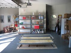 an empty garage with shelves and tools on the floor