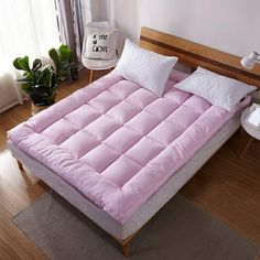 a bed that is in the middle of a room with pillows on top of it