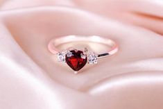 This stunning 925 sterling silver ring features a vibrant heart-shaped red cubic zirconia stone, symbolizing love and passion. Perfect for a beloved one, this ring is crafted with meticulous attention to detail, making it an ideal promise ring. The unique heart-cut stone adds a touch of elegance and romance, making it a standout piece. Whether for Valentine's Day or another special occasion, this ring is a thoughtful and meaningful gift. Its timeless design and the deep red hue of the stone capt Silver Heart-shaped Ruby Promise Ring, Silver Heart-shaped Ruby Ring, Heart-shaped Gemstone Ring For Valentine's Day, Valentine's Day Heart-shaped Sterling Silver Birthstone Ring, Heart-shaped Silver Ruby Ring For Valentine's Day, Red Stone, Stone Cuts, Jewelry Business, Stone Ring