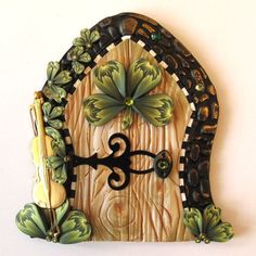 a clock that is made to look like a door with flowers on it and butterflies