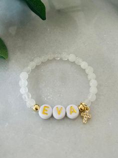 - The sweetest baby girl cross bracelet. Soft and delicate with dainty cross charm and personalized with name. Perfect goddaughter gift for baptism or Communion bracelet Bracelet is beaded on high quality stretch cord and secured.  - 4mm 18k gold filled accent beads   4.5mm gemstone beads ( white jade, rose quartz )   8mm cubic zirconia gold cross ‼️Young children MUST be supervised at all times while wearing jewelry. Contains small parts that could be a potential choking hazard. Jewelry should always be removed during sleep. Never leave young children unattended with our products. Supervision is required. It is at the customers discretion for the use of our products.  - Each purchase is sent in a velvet drawstring jewelry bag, making the perfect godchild gift, baptism bracelet, baby first Baptism Bracelet, Godchild Gift, Goddaughter Gifts, Wearing Jewelry, White Jade, Jewelry Bag, Cross Bracelet, Name Bracelet, Daughter Of God