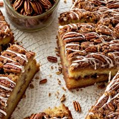 several pieces of cake on a plate with pecans in the background and one slice cut out