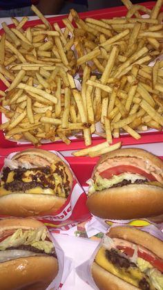 hot dogs and french fries in trays with condiments