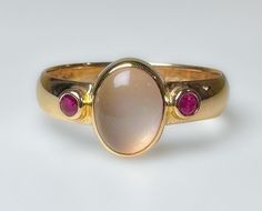 Stunning vintage, midcentury to 1970s...not entirely sure of its age. It does have an older hallmark. This is elegantly crafted ring with a comfortable low profile.  Featuring a clean luminescent 1.5ct Moonstone, flanked by two red Ruby's. Very pretty ring. 3.7g 14k solid yellow gold Hallmarked 4mm wide band Moonstone 1.5 ct Rubies 2 mm ea (.10ct) S 8 Us Resizable Excellent vintage condition Unique Ring Setting, Moonstone Gold Ring, Signet Rings Women Vintage, Vintage Ruby Ring, Rubin Ring, Ruby Ring Vintage, Moonstone Rings, June Birthstone Ring, Pretty Ring