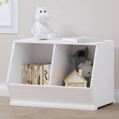 a white book shelf with books and a stuffed animal