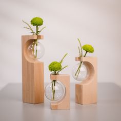 three vases with flowers in them sitting on a table