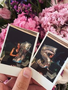 two polaroid photos are held up in front of pink flowers with the letter s on them