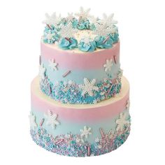 two tiered cake decorated with blue and pink frosting, snowflakes and stars