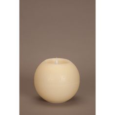 a white candle sitting in front of a brown background with the light on it's side