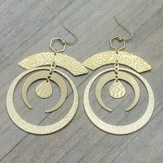 Look like the star of the night with these Large Gold Statement Hoop Earrings! Crafted with a brass gold finish and textured crescent hoops, these earrings will have you turning heads with the perfect combo of sophistication and style. Feeling sassy? Rock these out for a look that's out of this world! Brass textured components Brass ear hooks Length is 4" Created in studio - Wilmington, NC Bronze Brass Hoop Earrings With Oxidized Finish, Handmade Gold-tone Brass Hoop Earrings, Gold-tone Dangle Hoop Earrings In Brass, Intricate Brass Hoop Earrings, Gold-tone Brass Hoop Earrings, Statement Hoop Earrings, Brass Texture, Wilmington Nc, Brass Gold