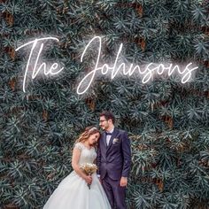 a bride and groom standing in front of a neon sign that says the johnsons