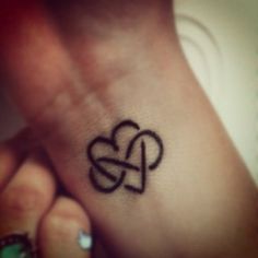 a small heart tattoo on the wrist