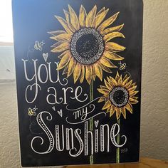 a chalkboard with the words you are my sunshine written on it and two sunflowers