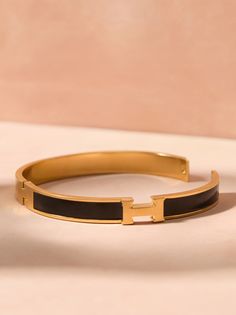 Embrace timeless elegance with this delicate gold bangle with black filled enamel. This bracelet will make a cherished addition to your everyday style. Football Dress, Christmas Trends, Gold Bangle, Altar'd State, Trending Dresses, Gold Bangles, Everyday Style, Top Trends, Stainless Steel Bracelet