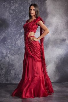 Scarlet red lehenga saree with tiered border, attached pleated draped pallu, floral pattern, tonal glass beads, crystals and stone embroidery. Paired with sweetheart neck embroidered blouse.
Components: 2
Pattern: Embroidered
Type Of Work: Crystals, Glass Beads and Stone Work
Neckline: Sweetheart Neck
Sleeve Type: Cap Sleeves
Fabric: Silk Organza, Chiffon 
Color: Red
Other Details: 
Feather fringe tasselled pallu border
Scalloped cut work hem
Occasion: Destination Wedding,Reception - Aza Fashion Varun Chakkilam, Work Crystals, Destination Wedding Reception, Stone Embroidery, Feather Fringe, Saree And Blouse, Pleated Drapes, Red Lehenga, Lehenga Saree