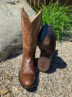 This classic brown western cowboy boot by R. Watson completes the perfect look for any occasion. R. Watson presents these brown bay apache cowhide western boots. These boots have a double row stitch pattern, R. Watson comfort system, all leather stacked heel, counters, solid steel shank, and 10 iron outsole and are 13″ total in height. Medium Round Toe Brown Bay Apache Cowhide Leather 13" Height Double-Row Stitching R. Watson Comfort System 10 Iron Outsole Leather Stacked Western Heel Rubber Hee Classic Goodyear Welted Moto Boots For Rodeo, Western Style Square Toe Boots For Western-themed Events, Western Goodyear Welted Boots For Fall, Western Moto Boots With Goodyear Welted Construction, Western Moto Boots With Goodyear Welt, Western Style Moto Boots With Goodyear Welted Construction, Western Style Moto Boots With Goodyear Welt, Goodyear Welted Moc Toe Moto Boots For Ranch, Classic Distressed Brown Boots For Ranch