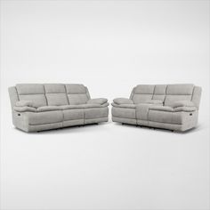 two reclining sofas sitting next to each other on top of a white floor