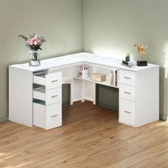 a white corner desk with drawers and a vase filled with flowers on the top shelf