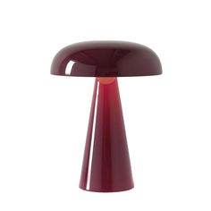 a red table lamp sitting on top of a white floor