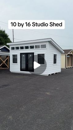 a small white building sitting in the middle of a parking lot