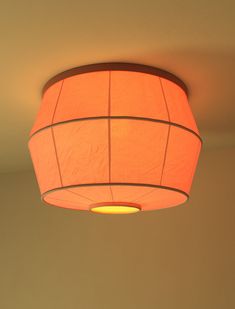 an orange lamp hanging from the ceiling in a room