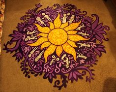 a purple and yellow flower is on the floor in front of a carpeted area