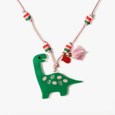 Be cute like a preciousaurus! Add an adorable dinosaur to any outfit. Their lovable preciousaurus is adorned with pastel glitter spots. The pink cord is adorned with matching pink and green beads giving it a sweet effect. • Made in Brazil • Fabric: 100% Acrylic • Adjustable Whimsical Green Necklace, Cute Adjustable Pink Necklaces, Pink Novelty Necklace For Birthday, Novelty Pink Necklace For Birthday, Green Playful Jewelry For Birthday, Playful Green Jewelry For Birthday, Pink Adjustable Necklace For Birthday, Playful Adjustable Necklace For Birthday, Playful Green Necklaces For Gift