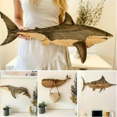 a woman holding a wooden shark sculpture in front of her face and several photos of it hanging on the wall