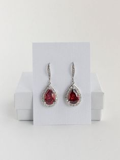 I've created these gorgeous red ruby cubic zirconia bridal tear drop dangle earrings in rhodium plated brass setting. Earrings feature a large teardrop with pear cut red ruby cubic zirconia center surrounded by tiny round zirconia crystals. Teardrop dangles from a cubic zirconia detailed ear wire. Total length of the earring is 3.8 cms. For matching necklace click: https://www.etsy.com/listing/469844682/red-ruby-cubic-zirconia-teardrop-bridal?ref=shop_home_active_26 For matching bracelet click: Red Wedding Jewelry, Red Crystal Jewelry, Crystal Wedding Necklace, Dressy Earrings, Red Bridesmaid, Blue Sapphire Bracelet, Teardrop Jewelry, Long Pearl Earrings, Crystal Earrings Wedding