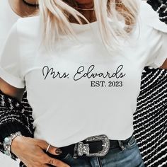 This is a Minimal Cursive Custom Mrs. Last Name Wedding Gift T-Shirt! White Custom Text T-shirt For Weddings, White Custom Text Top For Wedding, White T-shirt With Name Print For Anniversary, Leggings And Socks, Suit Accessories, Clothing Labels, Hat Hairstyles, Toddler Outfits, Wedding Gift