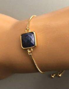 "Treat yourself or your love once to Lapis lazuli bracelet. This beautiful bracelet is dainty, minimal and elegant, this bracelet is the perfect finishing touch to any style or event. Great for everyday wear or for any occasion. Bolo Bracelet for Women is made from: - Natural Lapis gemstone set-in gold-plated bezel-12mm - Dainty Gold-plated brass chain Blue stone bracelet is fully adjustable. The silicone-lined round bead (7mm) slides along the chain and holds its position where you place it. To Luxury Gold Bracelets With Lapis Lazuli, Blue Stone Bracelet, Lapis Lazuli Bracelet, Bolo Bracelet, Opal Bracelet, Fancy Jewelry, September Birthstone, Opal Earrings, Nature Bracelets