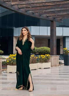 Deep forest green Velvet Kaftan delicately handworked with dabka, nakshi and zardozi on the neckline, shoulder slits, sleeves and front and back hemline and side slits. Kaftan Party Wear, Festive Green Dabka Kaftan, Festive Green Kaftan With Zari Work, Festive Green Zari Work Kaftan, Green Bollywood Style Kaftan With Resham Embroidery, Bollywood Style Green Kaftan With Resham Embroidery, Green V-neck Kaftan For Festive Occasions, Green Bollywood Kaftan With Dabka Work, Green Floor-length Kaftan With Zari Work