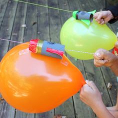 two people are holding balloons on a string