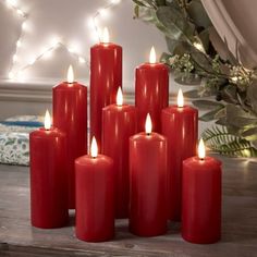 six red candles sitting on top of a wooden table