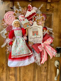 a door hanger that has a doll and some cookies on it in front of a wooden door