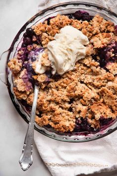 a close up of a plate of food with ice cream on top and the words healthy blueberry crisp above it