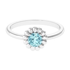 a white gold ring with an aqua blue topaze stone in the center and two small flowers on each side