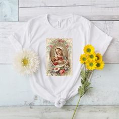 Beautiful shirt featuring the Virgin Mary and baby Jesus. This is the perfect gift for yourself or loved ones! 100% super soft cotton short sleeve Tshirt. Vintage + distressed design. ♡Measurements:Available in sizes S-3XLComfy, unisex tee. Roll up the sleeves and tie the shirt for an adorable fit!If you prefer a tighter fitting shirt, we recommend sizing down.*If you prefer women's fit or V-neck, leave us a note and we can customize for you!*Care Instructions:Machine wash: warmTumble dry: low h White Cotton T-shirt As Gift, White T-shirt For Mother's Day Gift, White Short Sleeve Top For Gift, White Short Sleeve Top As Gift, White Letter Print T-shirt As Gift, White Graphic Tee As A Gift, White Letter Print Shirt As A Gift, White Letter Print Shirt As Gift, White Cotton Shirt As A Gift