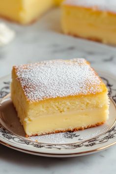 a piece of cake sitting on top of a white and black plate covered in powdered sugar