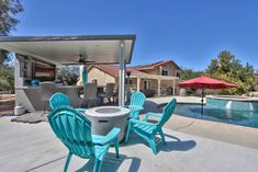 a patio with chairs and an umbrella next to a pool