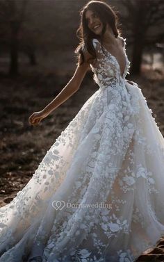 a woman in a wedding dress is walking through the woods with her hand on her hip