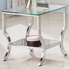 a glass and chrome end table with a shoe on it's footrests