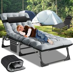 a child laying on top of a blue chaise lounge chair next to camping gear