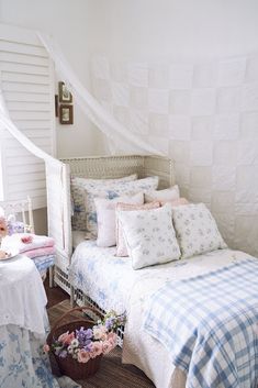 a white bed sitting next to a window covered in curtains