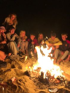 a group of people sitting around a campfire