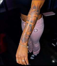 a woman with a cross tattoo on her arm