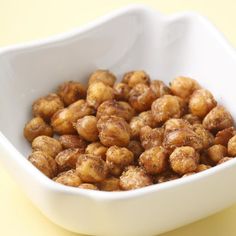 a white bowl filled with nuts on top of a yellow table