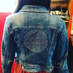 the back of a woman's jean jacket in a store